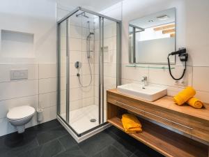 a bathroom with a shower and a sink and a toilet at Nowders Apartments und Zimmer in Nauders