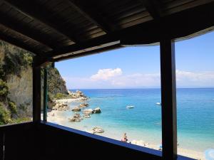 een raam met uitzicht op het strand bij Fetsis Apartments in Ayios Nikitas