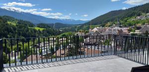 ein Balkon mit Blick auf die Stadt und die Berge in der Unterkunft Molaris Lodge in Mühlbach