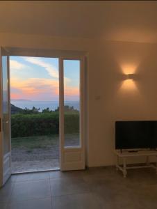 a living room with a flat screen tv and a window at Alta Marina in Marciana Marina