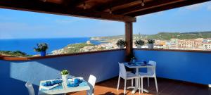 een balkon met 2 tafels en uitzicht op de oceaan bij B&B Monte Becco in Santa Teresa Gallura