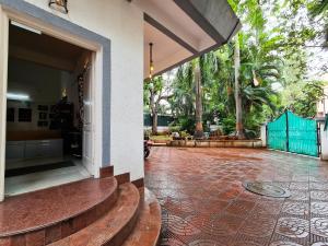 a house with a courtyard with a door and stairs at Hostel Lifespace- Garden Bungalow with Pods, CoWork & Cafe in Pune