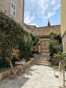 a patio with a table and chairs and a building at Old town studio apartments in Makarska