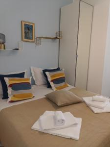 - un lit avec des serviettes et des oreillers blancs dans l'établissement Loft Profumo di Mare, à Giardini Naxos