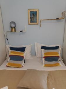 - un lit blanc avec quatre oreillers et une photo sur le mur dans l'établissement Loft Profumo di Mare, à Giardini Naxos