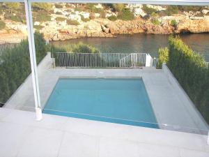 a swimming pool on a patio next to a river at Villa Mar in Cala en Blanes