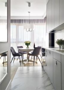 a kitchen and dining room with a table and chairs at APARTAMENTY NADJEZIORNE z tarasem na dachu in Ełk