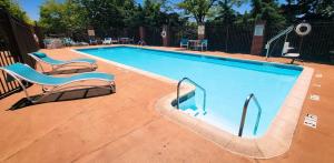 a swimming pool with two lounge chairs next to it at Holiday Inn Express Harrisburg East by IHG in Harrisburg