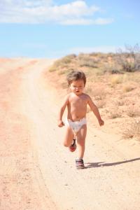 a young boy riding a skateboard down a dirt road at Shash Dine' EcoRetreat in Page