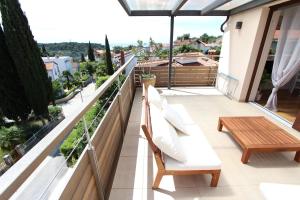 balcón con muebles blancos y vistas a la ciudad en Apartments Makado, en Rovinj