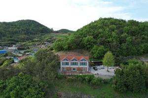 eine Luftansicht eines Hauses auf einem Hügel in der Unterkunft Oh My Family Pension in Yeosu