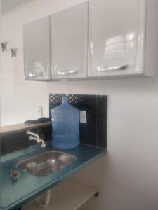 a kitchen counter with a sink and a blue jug at AP mobiliado em Guaibim in Guaibim