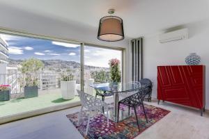 comedor con mesa de cristal y ventana grande en IMMOGROOM - Apartment with terrace - AC - Parking, en Cannes