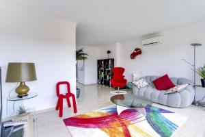 een woonkamer met een bank en een rode stoel bij IMMOGROOM - Apartment with terrace - AC - Parking in Cannes