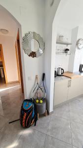 a room with a backpack and tennis rackets and a mirror at Arenal in Jávea
