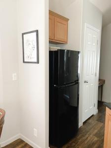 a black refrigerator in a kitchen next to a door at Lazy Z Resort in Twain Harte