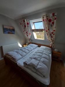 a large bed in a bedroom with a window at Luise 2 in Kaltenhof