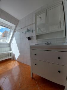 a bathroom with a sink and a mirror and a window at Luise 2 in Kaltenhof