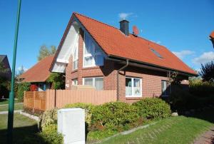 a brick house with a red roof at Langenwerder in Kaltenhof