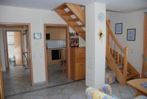 a living room with a kitchen and a staircase at Langenwerder in Kaltenhof