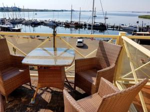 a table and chairs on a balcony with a marina at Seepanorama 1 in Kirchdorf