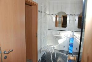 a bathroom with a white sink and a white stool at Langenwerder in Kaltenhof +14 photos