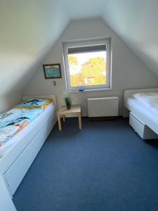 a attic bedroom with two beds and a window at Fenster in Kaltenhof