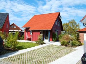 een rood huis met een oranje dak bij Hexenhäuschen in Kaltenhof