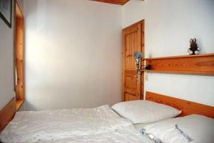 a small bedroom with a bed with a wooden headboard at Hexenhäuschen in Kaltenhof