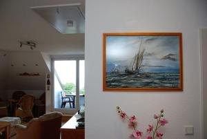 a living room with a painting of a ship on the wall at Schöner Blick in Am Schwarzen Busch