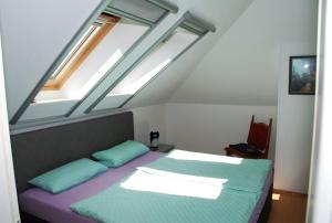 a bedroom with a bed with two pillows and two windows at Schöner Blick in Am Schwarzen Busch