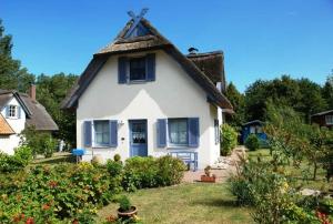 a large white house with a thatched roof at Hagebutte in Am Schwarzen Busch