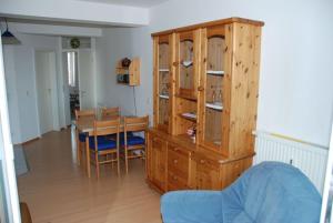 a living room with a table and a wooden cabinet at Ostseeblick Ferienwohnung in Am Schwarzen Busch