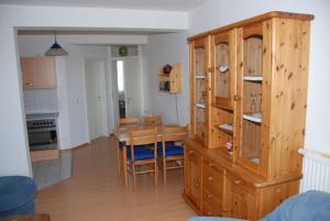 a kitchen and dining room with a table and a wooden cabinet at Ostseeblick Ferienwohnung in Am Schwarzen Busch +12 photos