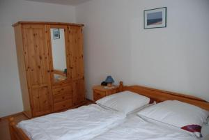 a bedroom with a bed and a wooden cabinet at Ostseeblick Ferienwohnung in Am Schwarzen Busch