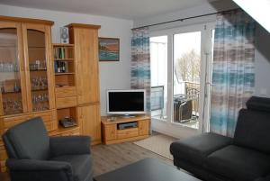 a living room with a tv and a couch and a window at Seesternchen in Am Schwarzen Busch
