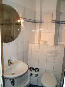 a bathroom with a sink and a toilet and a mirror at Seesternchen in Am Schwarzen Busch +11 photos