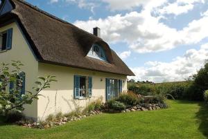 une maison blanche avec un toit marron et une cour dans l'établissement Lavendel, à Am Schwarzen Busch