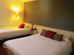 Postel nebo postele na pokoji v ubytování Hotel Amys Voreppe