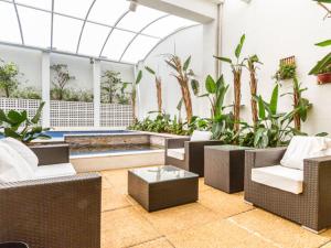 a lobby with chairs and a pool and plants at Vossa Bossa Bela Cintra in Sao Paulo
