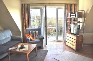a living room with a couch and a tv and a table at Andrea in Timmendorf