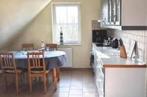 a kitchen with a table and chairs and a sink at Andrea in Timmendorf