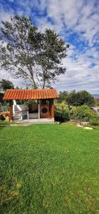 a gazebo with an orange roof in a field at Villa Monica HR in Villa de Leyva