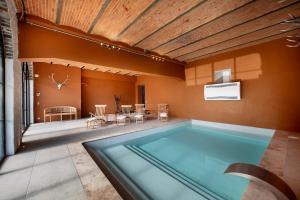 a swimming pool in a house with a ceiling at Domaine de Priesmont in Vielsalm