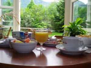 a table with food and a glass of orange juice at Hotel Amys Voreppe in Voreppe