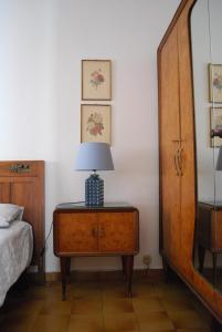 a bedroom with a bed and a lamp on a dresser at La casetta del nonno Giampi in Sesto Calende