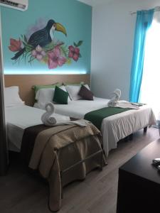 two beds in a room with a painting on the wall at Sweet Dreams in San Vito lo Capo