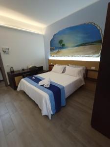 a hotel room with a bed and a painting on the wall at Sweet Dreams in San Vito lo Capo
