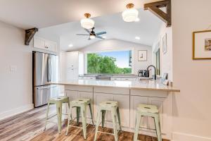 a kitchen with white cabinets and green stools at Lake Folly in Folly Beach
