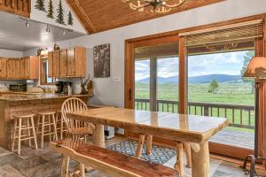 eine Küche mit einem Tisch und einem großen Fenster in der Unterkunft Mountain View Cabin in Angel Fire
